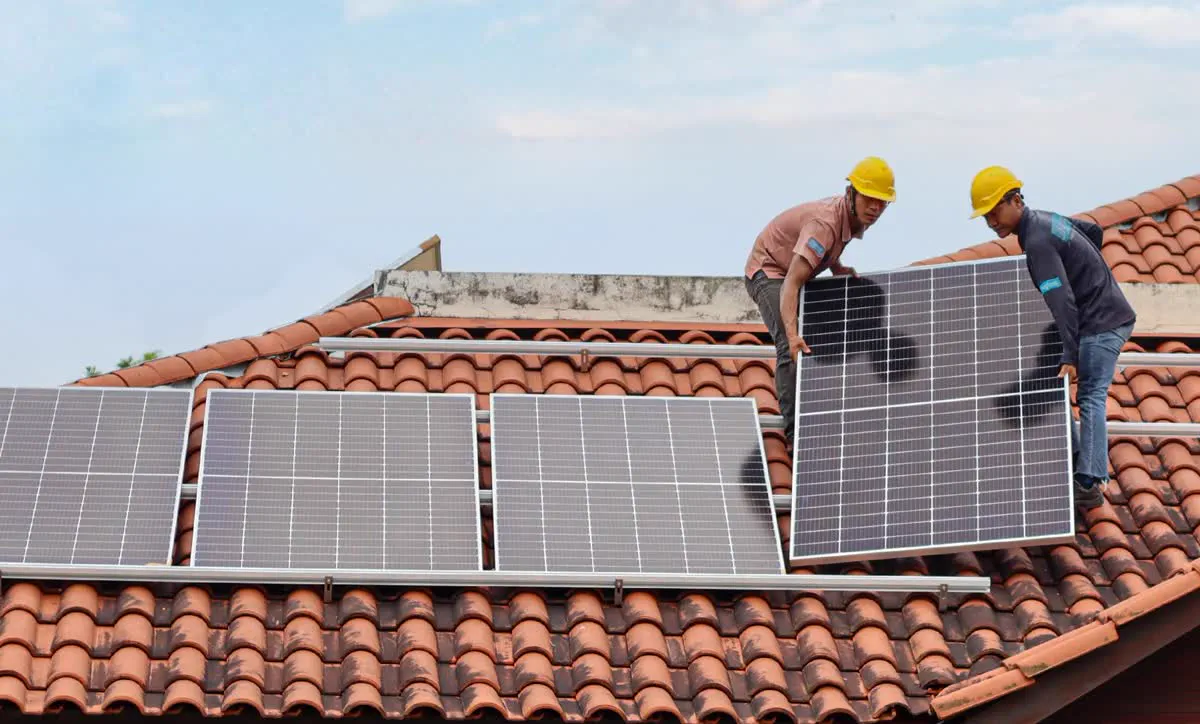 Pekerja De Solar memasang panel solar atas bumbung genting rumah