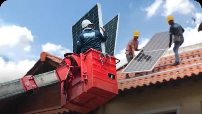 Pekerja De Solar memasang panel solar menggunakan kren bakul